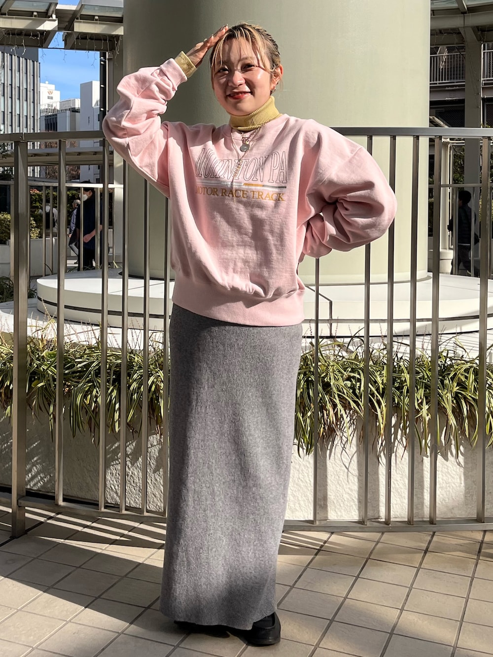 グレー系のスカート、ピンク系のスウェット、ホワイト系のブルゾンを着用したレディースの冬コーディネートの4枚目の写真