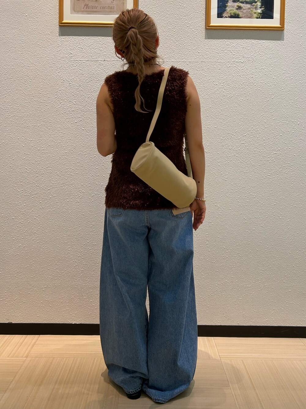 ブルー系のデニムパンツ、ブラウン系のニット/セーター、ブラック系のベルトを着用したレディースの夏コーディネートの4枚目の写真