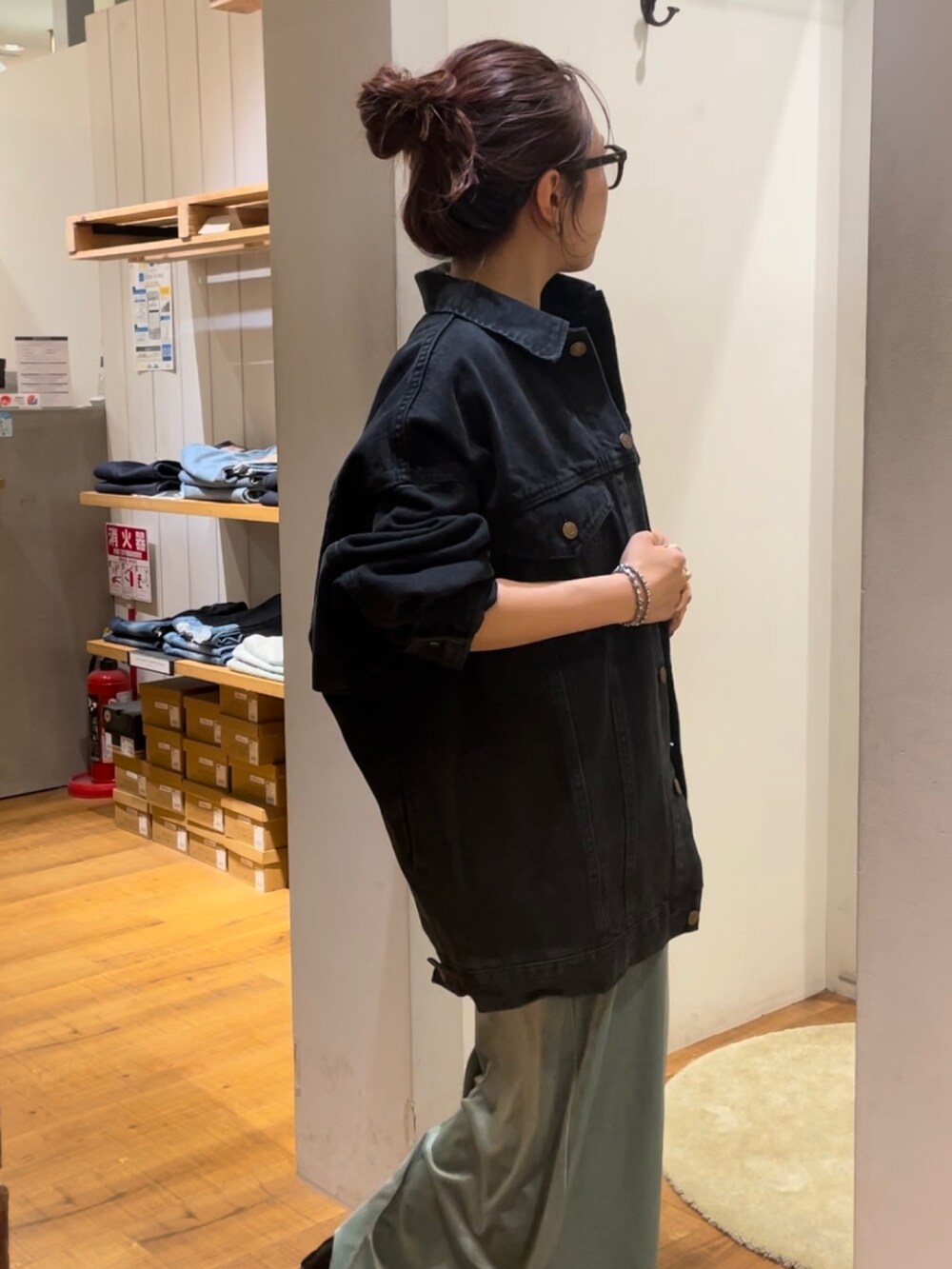 グリーン系のワンピース、ブラック系のデニムジャケット、ブラック系のメガネを着用したレディースの秋コーディネートの6枚目の写真