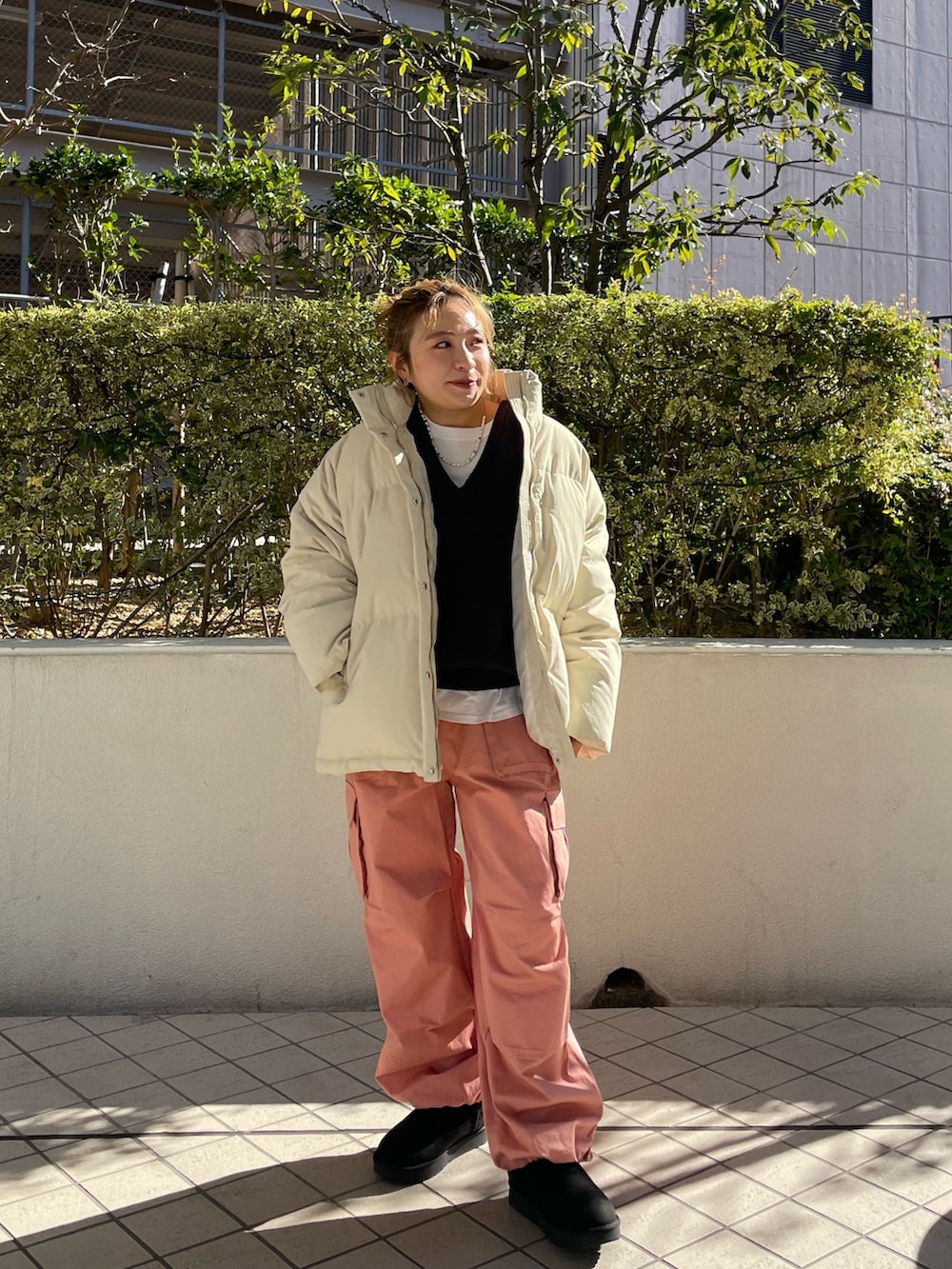 グレー系のニット/セーター、ホワイト系のダウンジャケット/コート、ピンク系のカーゴパンツを着用したレディースの冬コーディネートの2枚目の写真