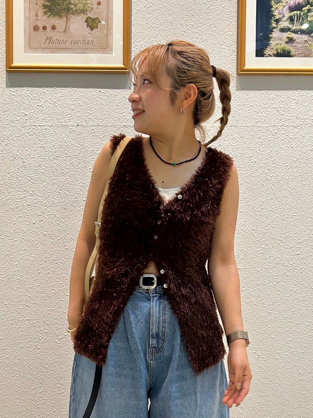 ブルー系のデニムパンツ、ブラウン系のニット/セーター、ブラック系のベルトを着用したレディースの夏コーディネートの5枚目の写真