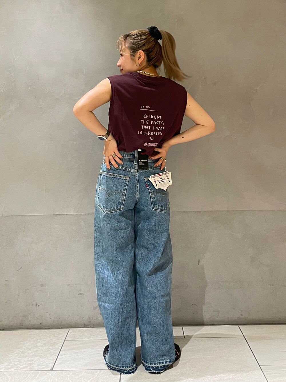 ブルー系のデニムパンツ、ブラウン系のTシャツ/カットソーを着用したレディースの夏コーディネートの3枚目の写真