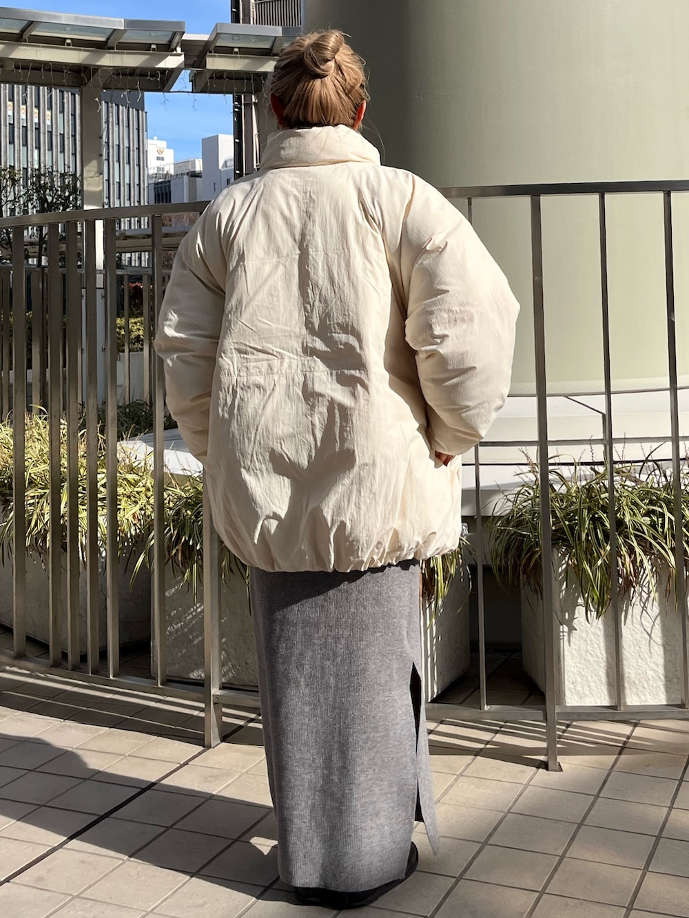 グレー系のスカート、ピンク系のスウェット、ホワイト系のブルゾンを着用したレディースの冬コーディネートの3枚目の写真