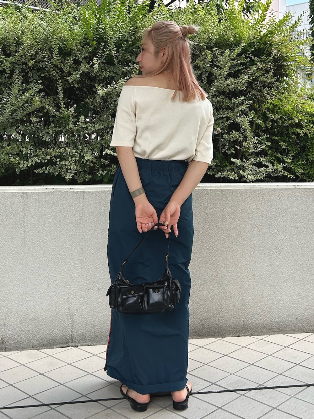ホワイト系のTシャツ/カットソー、ブルー系のスカート、ブラック系のハンドバッグを着用したレディースの夏コーディネートの3枚目の写真