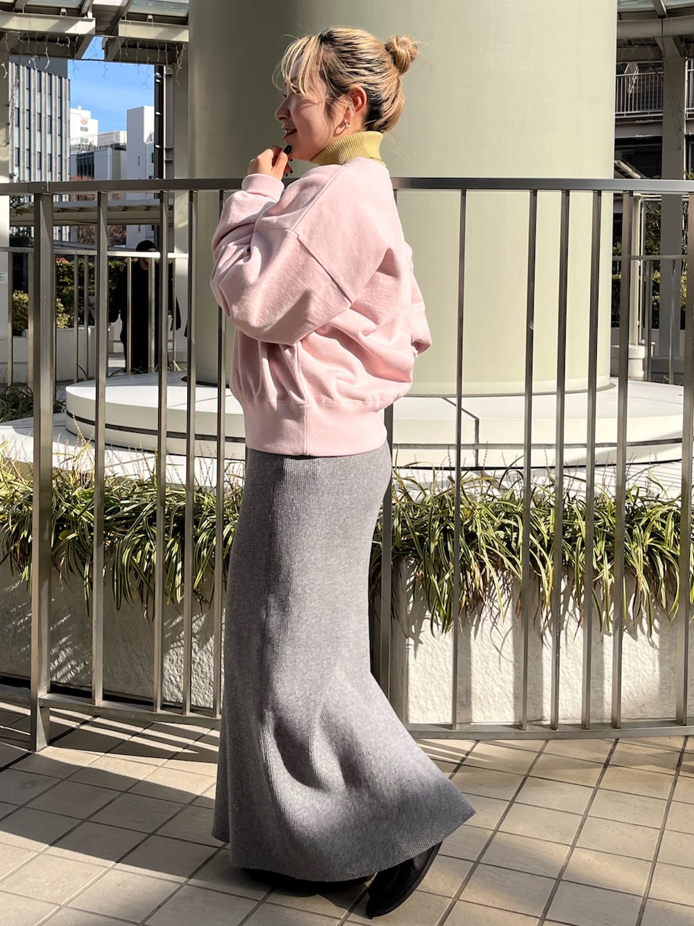 グレー系のスカート、ピンク系のスウェット、ホワイト系のブルゾンを着用したレディースの冬コーディネートの5枚目の写真