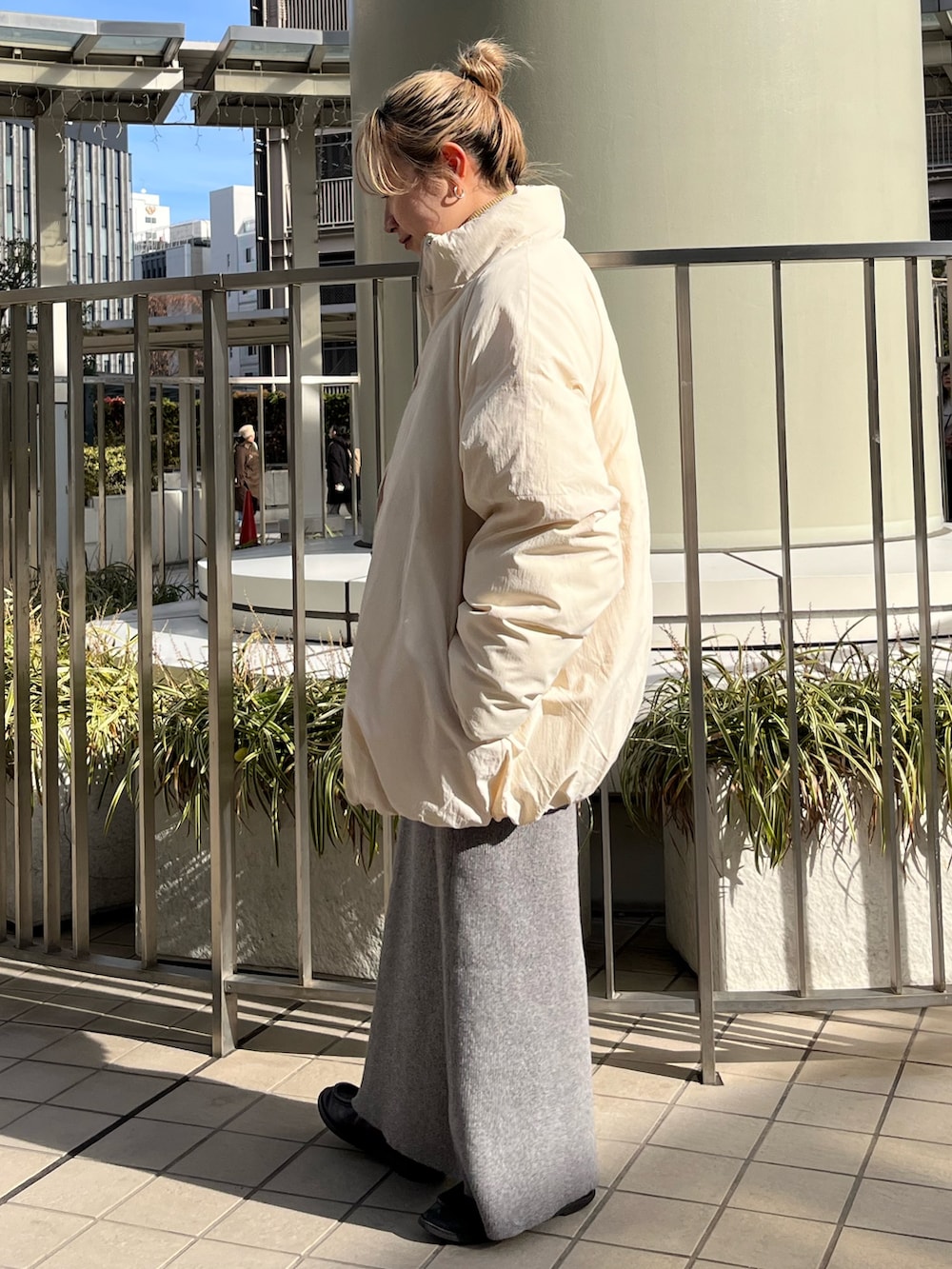 グレー系のスカート、ピンク系のスウェット、ホワイト系のブルゾンを着用したレディースの冬コーディネートの2枚目の写真