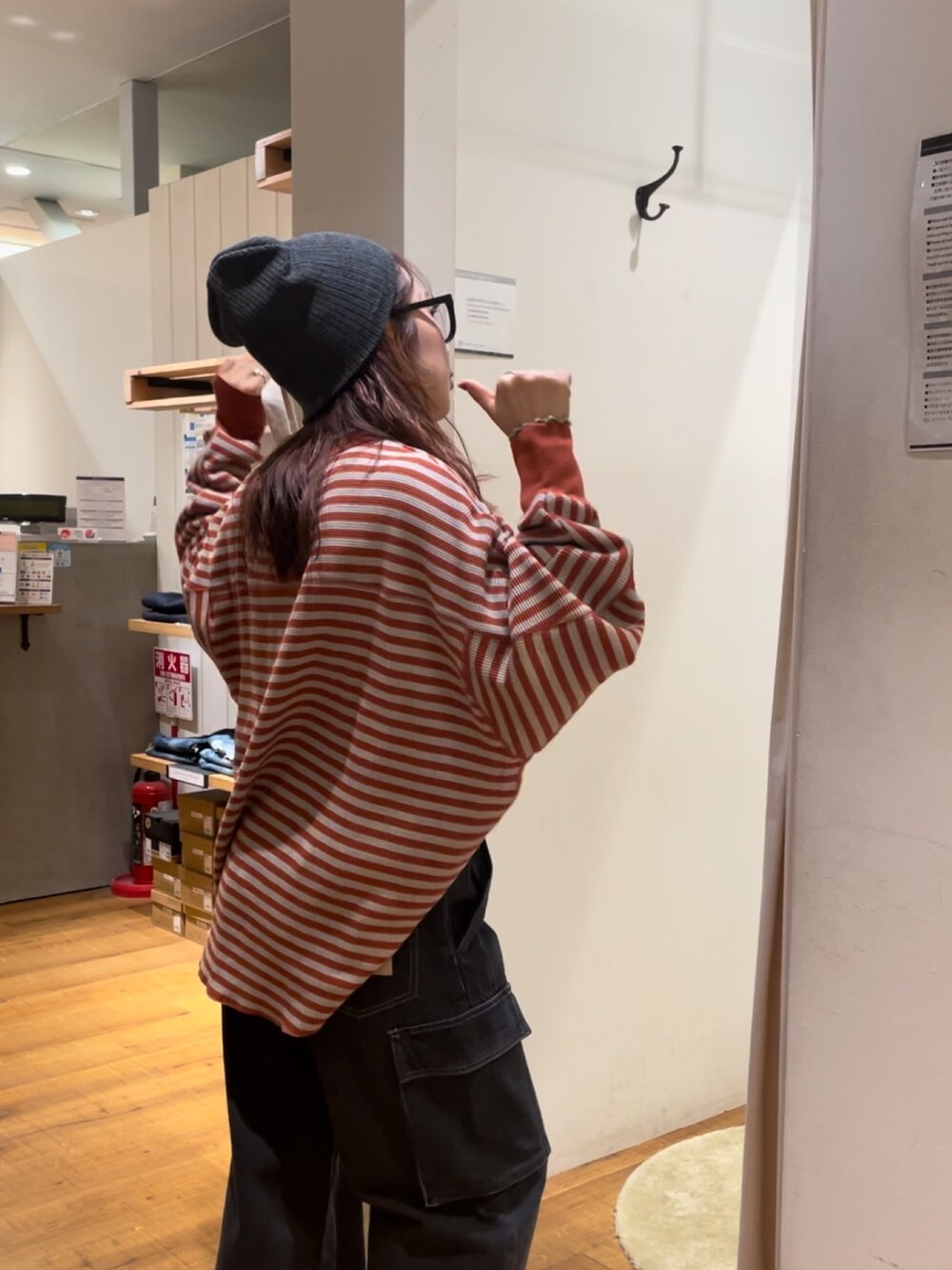 オレンジ系のTシャツ/カットソー、ブラック系のデニムパンツ、レッド系のトートバッグを着用したレディースの秋コーディネートの4枚目の写真