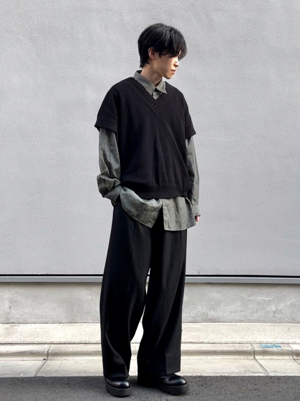 ブラック系のスラックス、ブラック系のベスト、グリーン系のシャツ/ブラウスを着用したメンズの春コーディネートの2枚目の写真