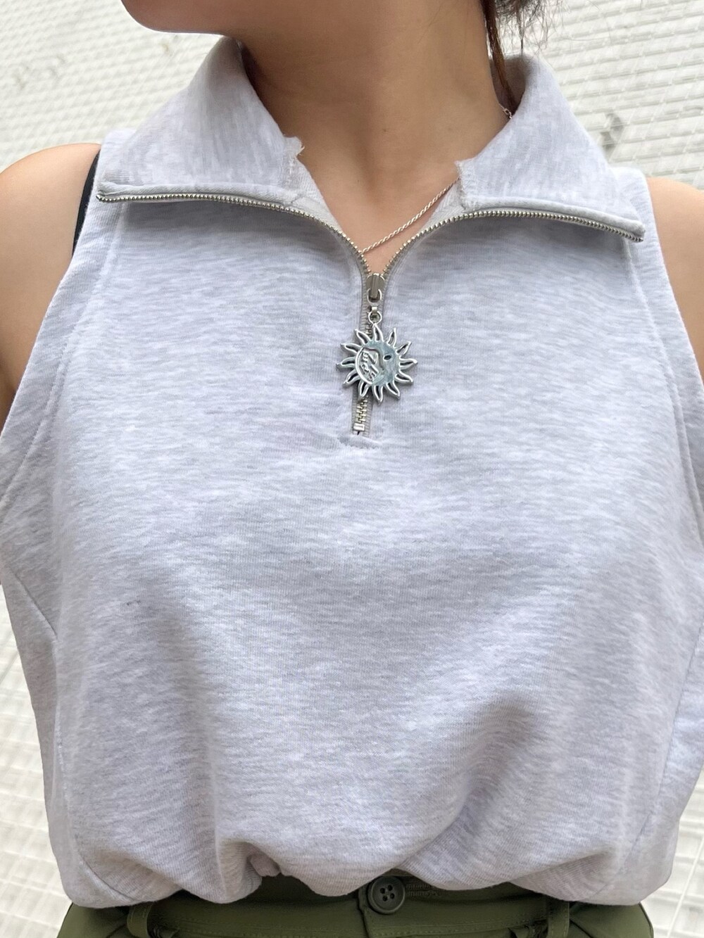 ホワイト系のハンドバッグ、グリーン系のカーゴパンツ、ブラック系のサンダルを着用したレディースの春コーディネートの3枚目の写真