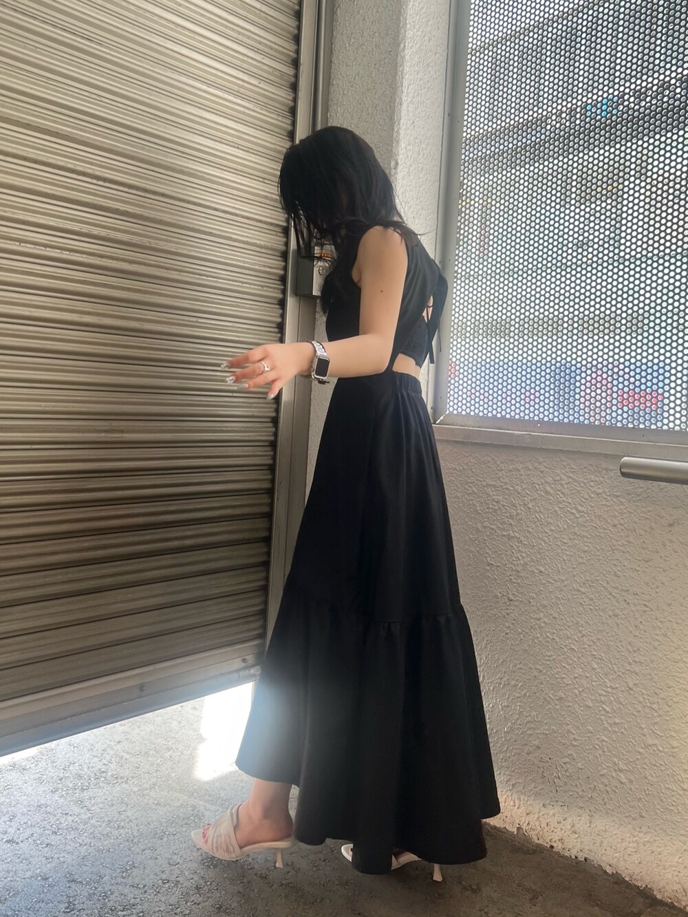 ブラック系のワンピース、ホワイト系のサンダルを着用したレディースの夏コーディネートの3枚目の写真