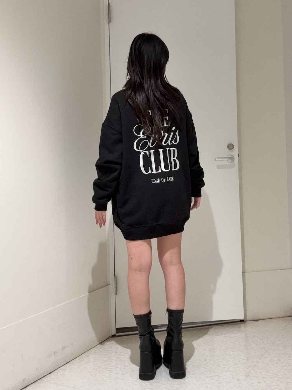 ブラック系のスウェット、ブラック系のブーツ、ブルー系のデニムパンツを着用したレディースの冬コーディネートの3枚目の写真