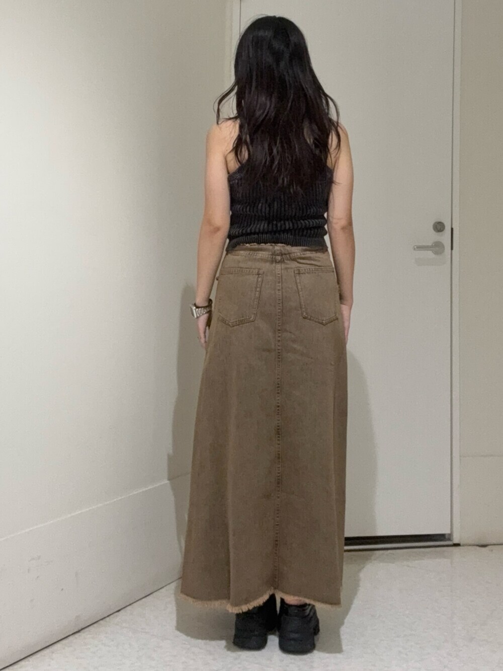 ブラウン系のサンダル、ブルー系のデニムスカート、ブラック系のニット/セーターを着用したレディースの夏コーディネートの3枚目の写真