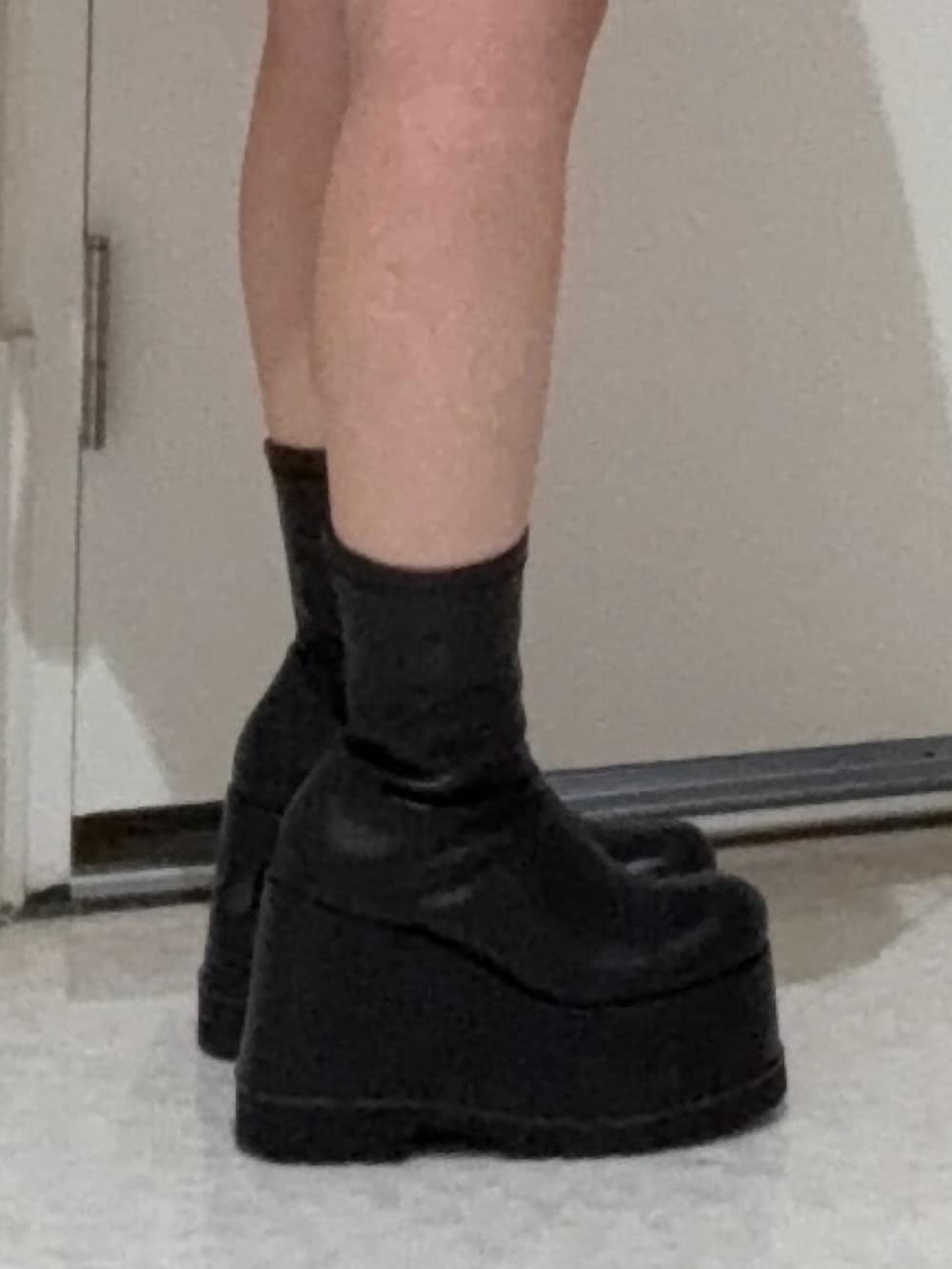 ブラック系のデニムパンツ、ブラック系のブーツ、ブラック系のニット/セーターを着用したレディースの春コーディネートの5枚目の写真