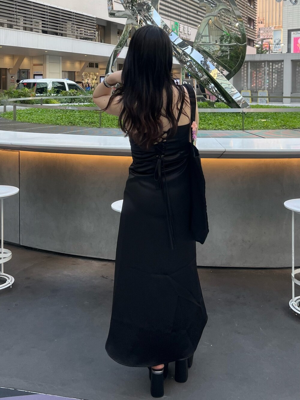 ブラック系のワンピース、ブラック系のトートバッグ、ブラック系のサンダルを着用したレディースの夏コーディネートの4枚目の写真