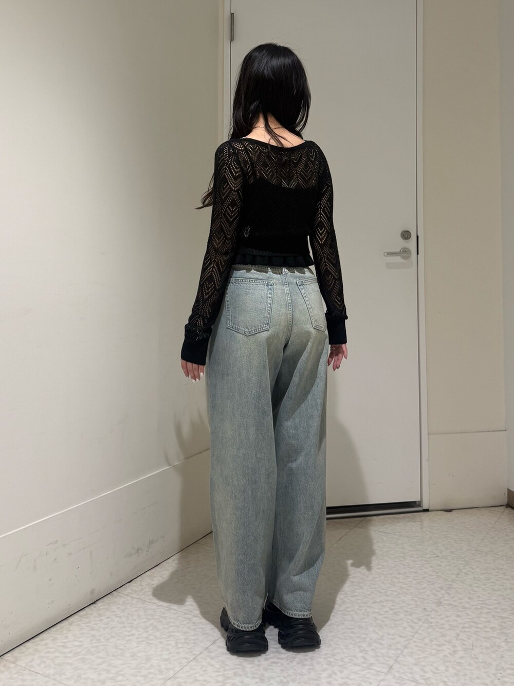 ブラック系のカーディガン/ボレロ、ブルー系のデニムパンツ、ブラック系のサンダルを着用したレディースの春コーディネートの3枚目の写真
