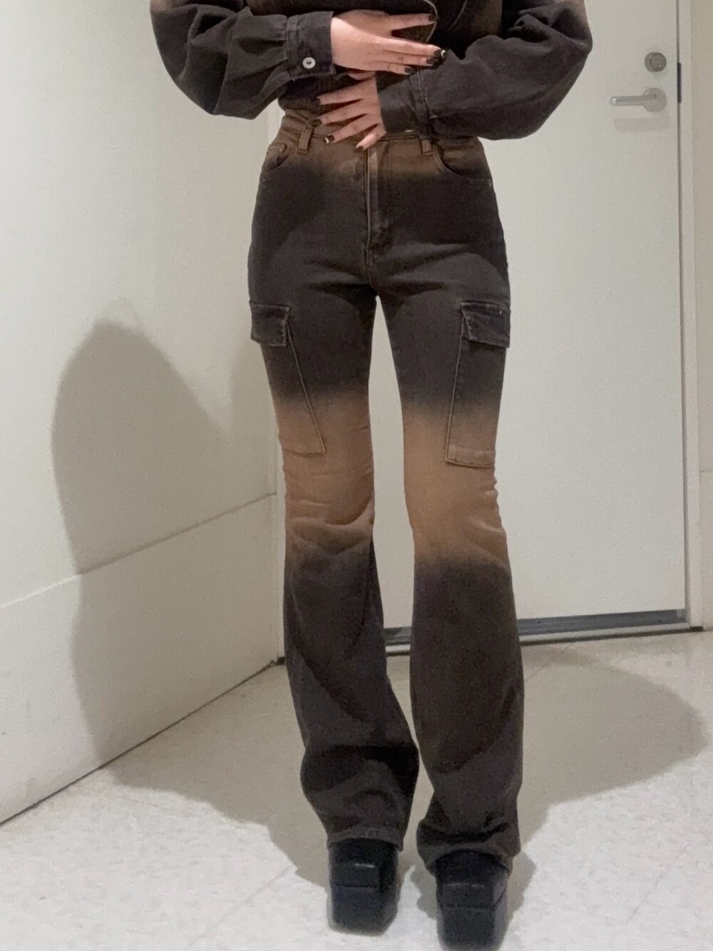 ブラック系のブーツ、ブラウン系のタンクトップ、ブラウン系のデニムジャケットを着用したレディースの秋コーディネートの4枚目の写真