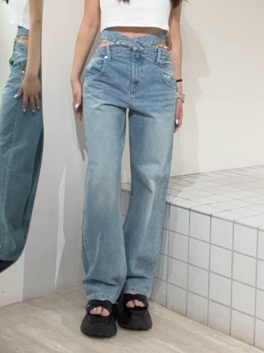 ブラック系のサンダル、ブルー系のデニムパンツ、ホワイト系のTシャツ/カットソーを着用したレディースの夏コーディネートの5枚目の写真