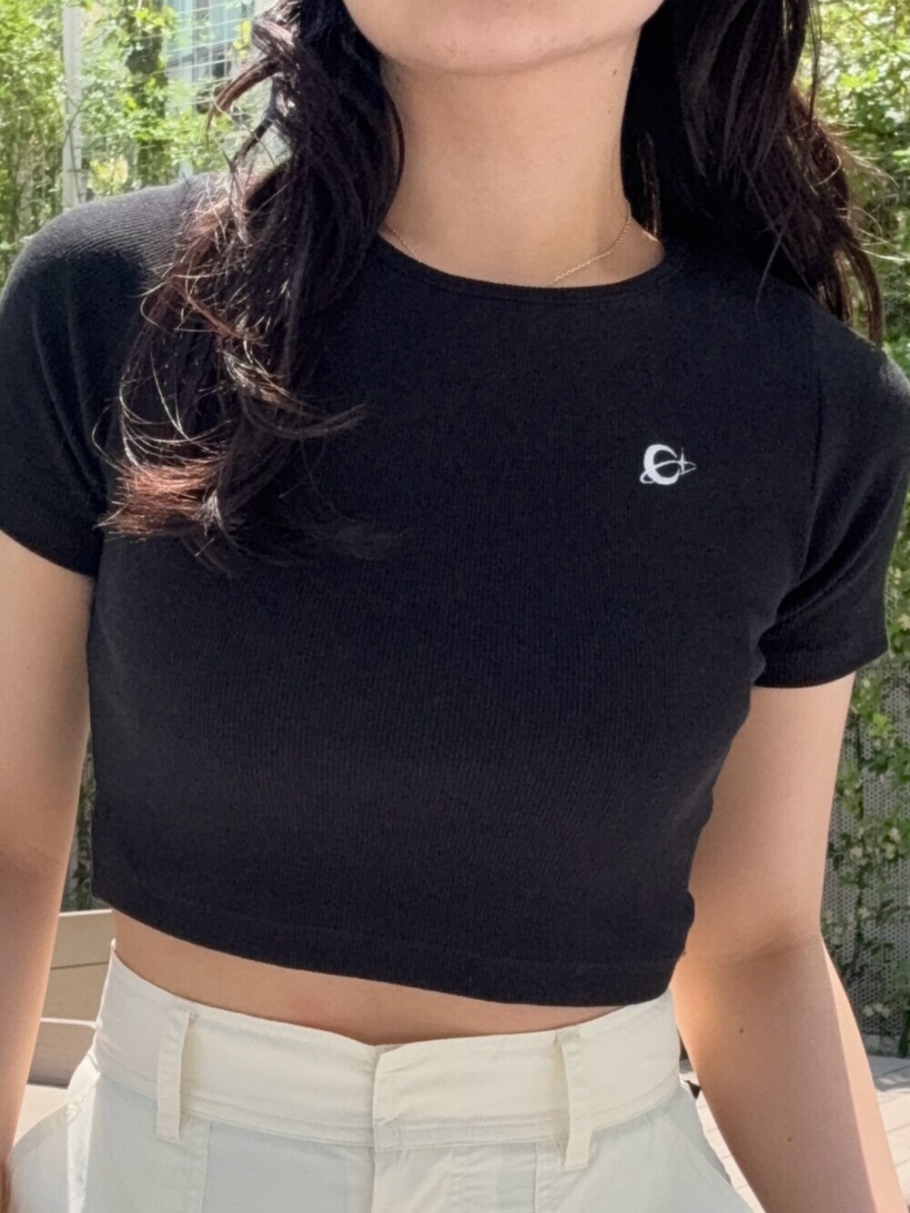 ブラウン系のサンダル、ブラック系のTシャツ/カットソー、ホワイト系のカーゴパンツを着用したレディースの春コーディネートの4枚目の写真