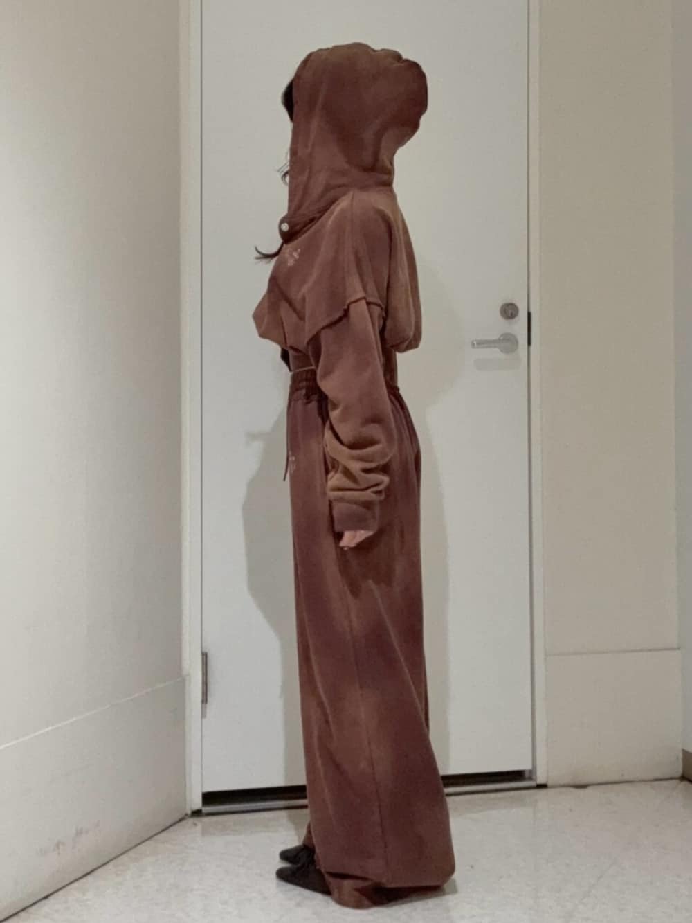 ブラウン系のパーカー、ブラウン系のスウェットパンツ、ブラウン系のサンダルを着用したレディースの冬コーディネートの2枚目の写真