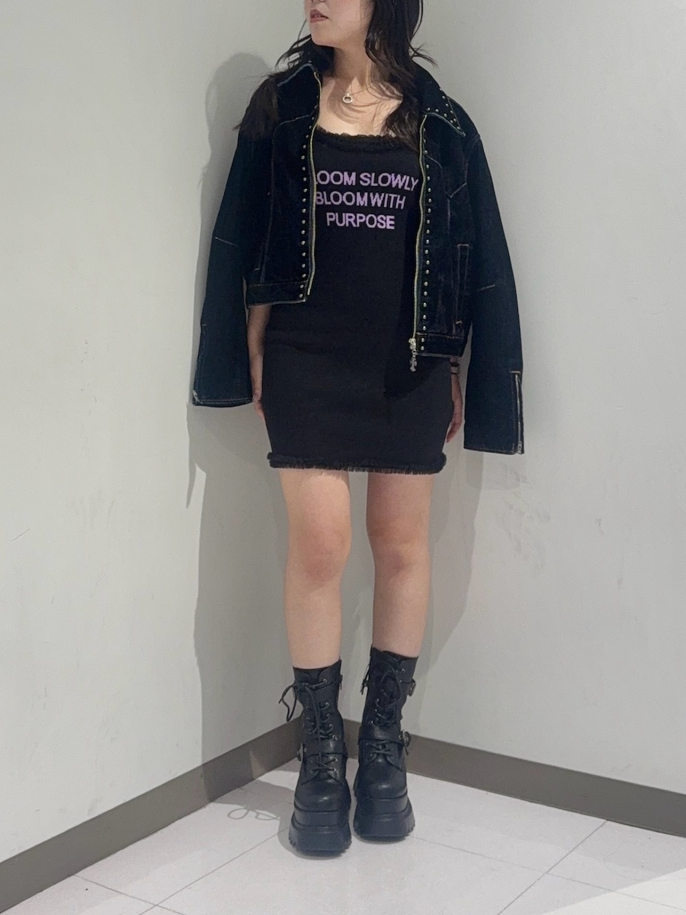 ブルー系のデニムジャケット、ブラック系のブーツ、ブラック系のワンピースを着用したレディースの夏コーディネートの2枚目の写真