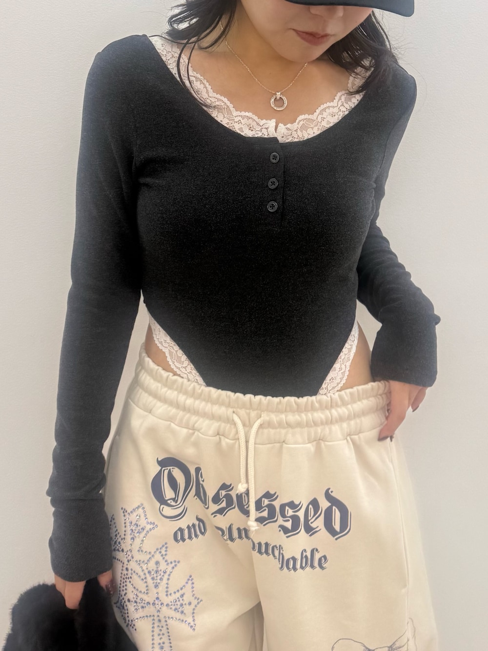 グレー系のTシャツ/カットソー、ホワイト系のスウェットパンツ、ブラック系のショルダーバッグを着用したレディースの秋コーディネートの4枚目の写真
