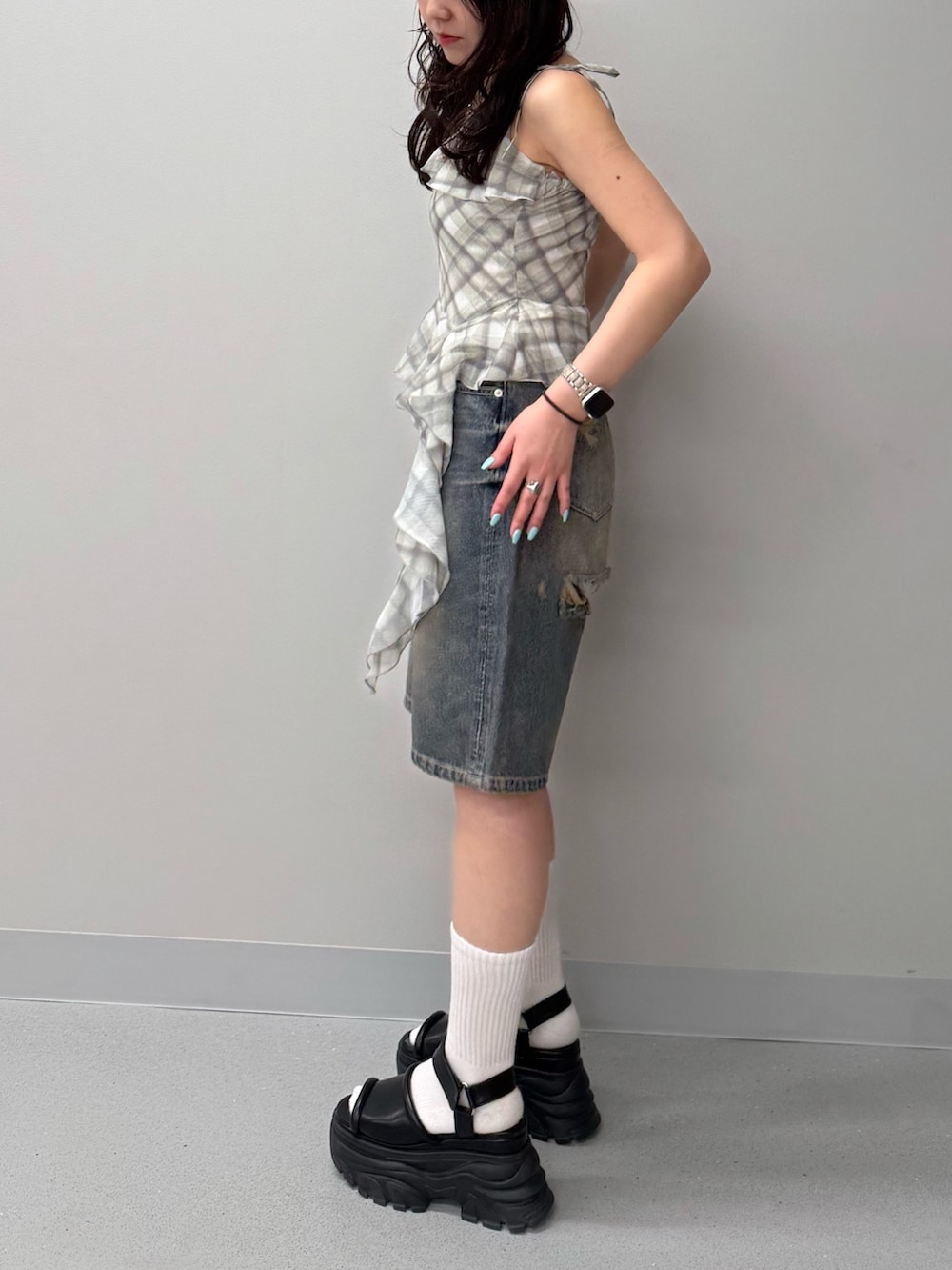 ブルー系のデニムパンツ、イエロー系のキャミソール、ブラウン系のサンダルを着用したレディースの春コーディネートの2枚目の写真