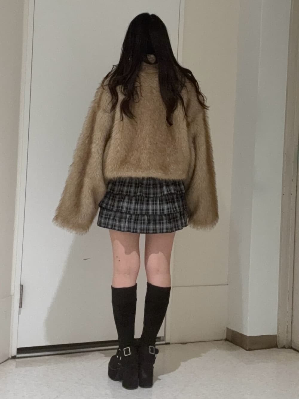 ブラック系のブーツ、ブラック系のスカート、ブラウン系のブルゾンを着用したレディースの冬コーディネートの3枚目の写真