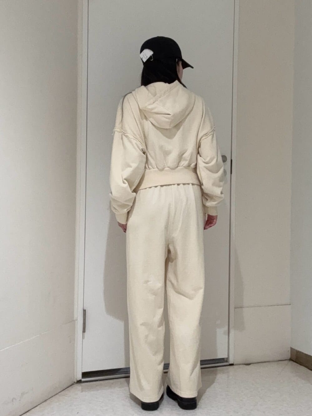 ブラック系のブーツ、ホワイト系のパーカー、ホワイト系のスウェットパンツを着用したレディースの春コーディネートの3枚目の写真