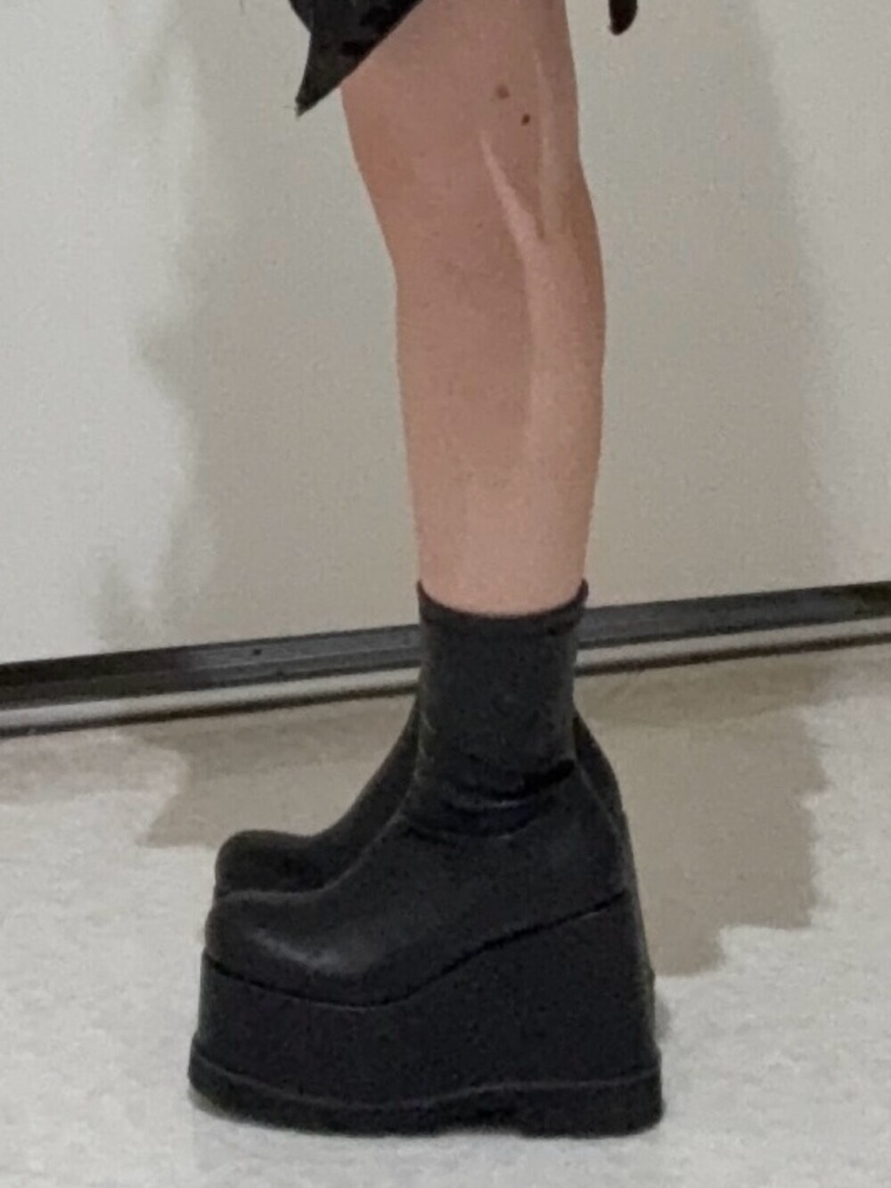 ブラック系のデニムパンツ、ブラック系のブーツ、ホワイト系のカーディガン/ボレロを着用したレディースの春コーディネートの5枚目の写真