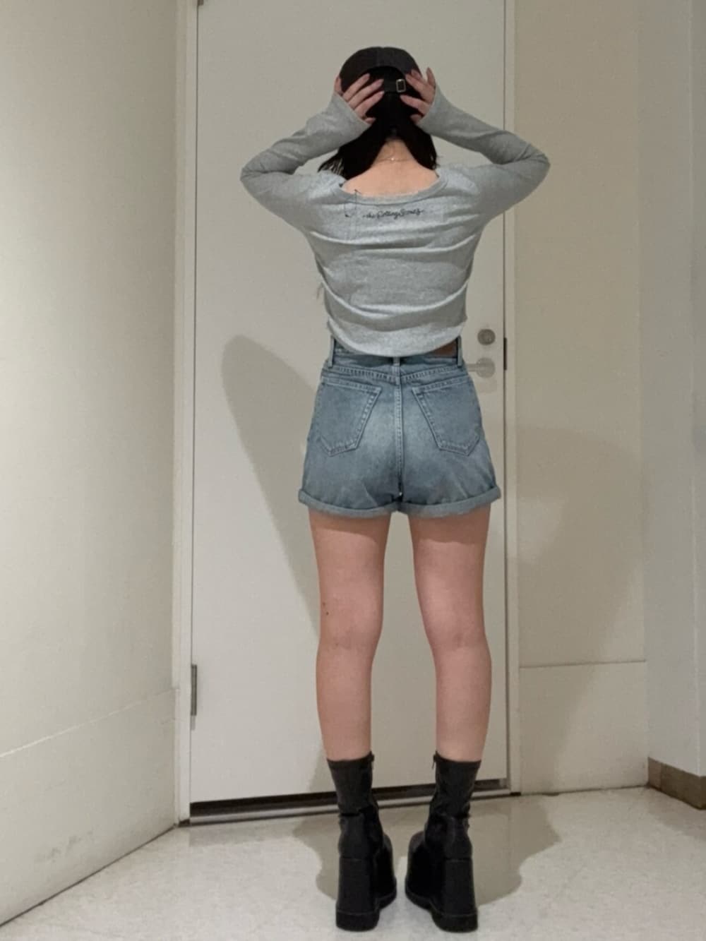 ブラック系のブーツ、ブルー系のデニムパンツ、グレー系のTシャツ/カットソーを着用したレディースの冬コーディネートの3枚目の写真