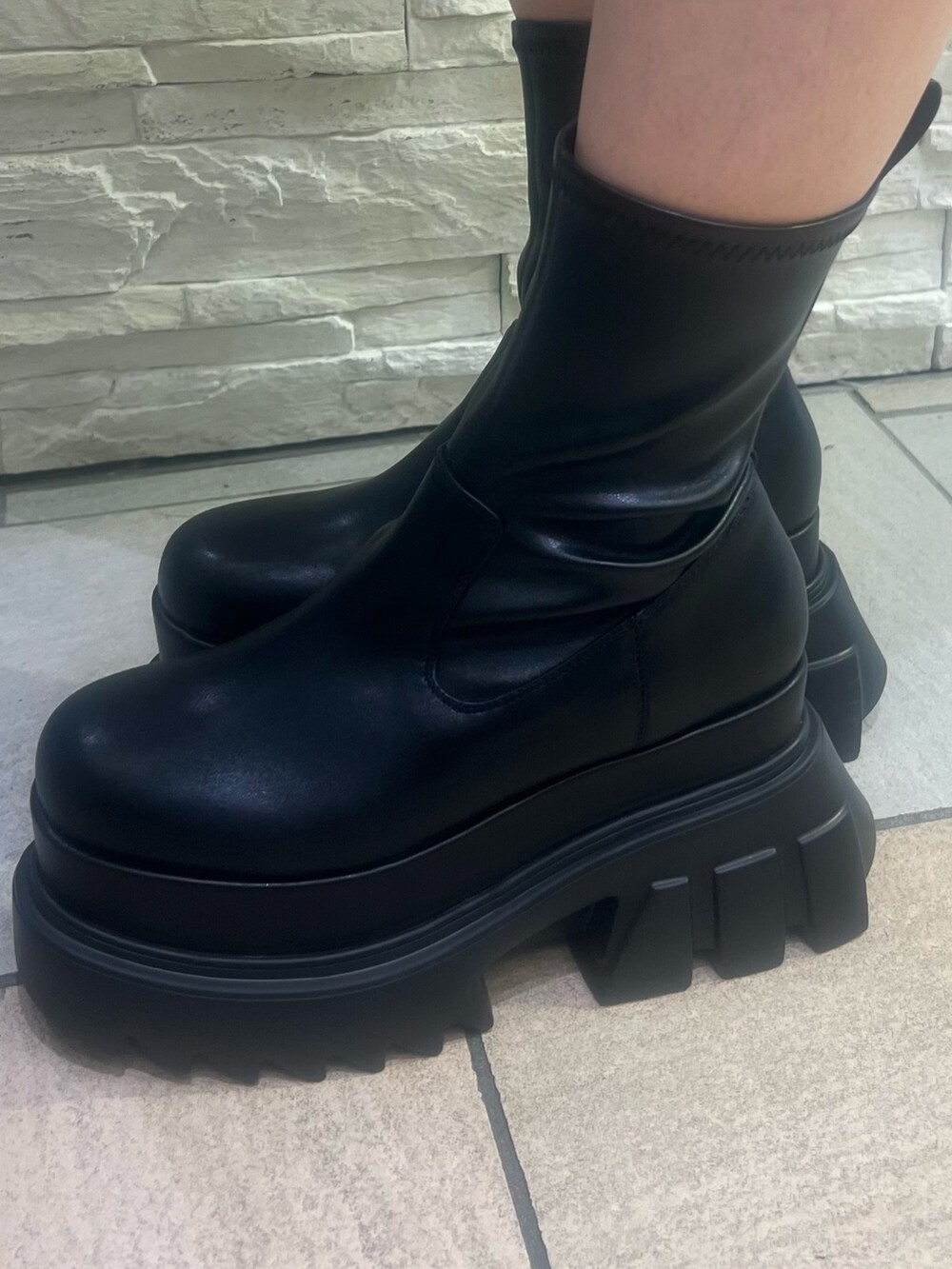 ブラック系のブーツ、ブラック系のブルゾン、ホワイト系のスカートを着用したレディースの秋コーディネートの7枚目の写真