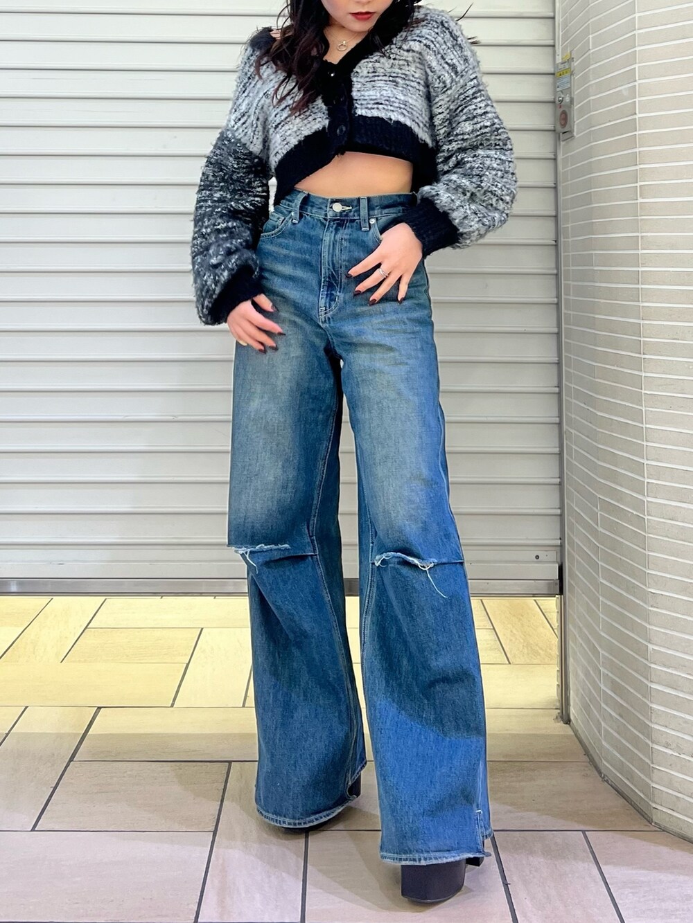 ブルー系のデニムパンツ、ブラック系のカーディガン/ボレロ、ブラック系のブーツを着用したレディースの冬コーディネートの3枚目の写真