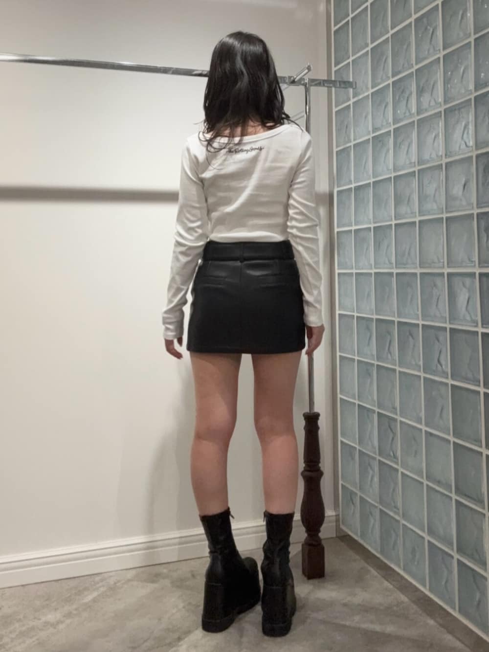 ブラック系のブーツ、ブラック系のスカート、ホワイト系のTシャツ/カットソーを着用したレディースの冬コーディネートの3枚目の写真