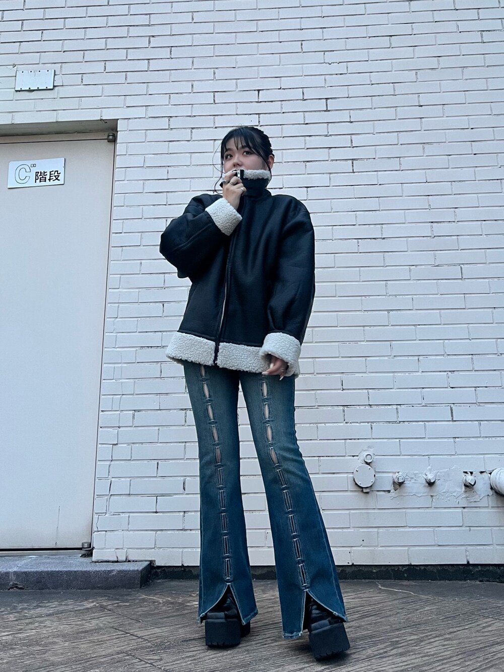 その他のムートンコート、ブルー系のデニムパンツ、ブラック系のショルダーバッグを着用したレディースの夏コーディネートの4枚目の写真