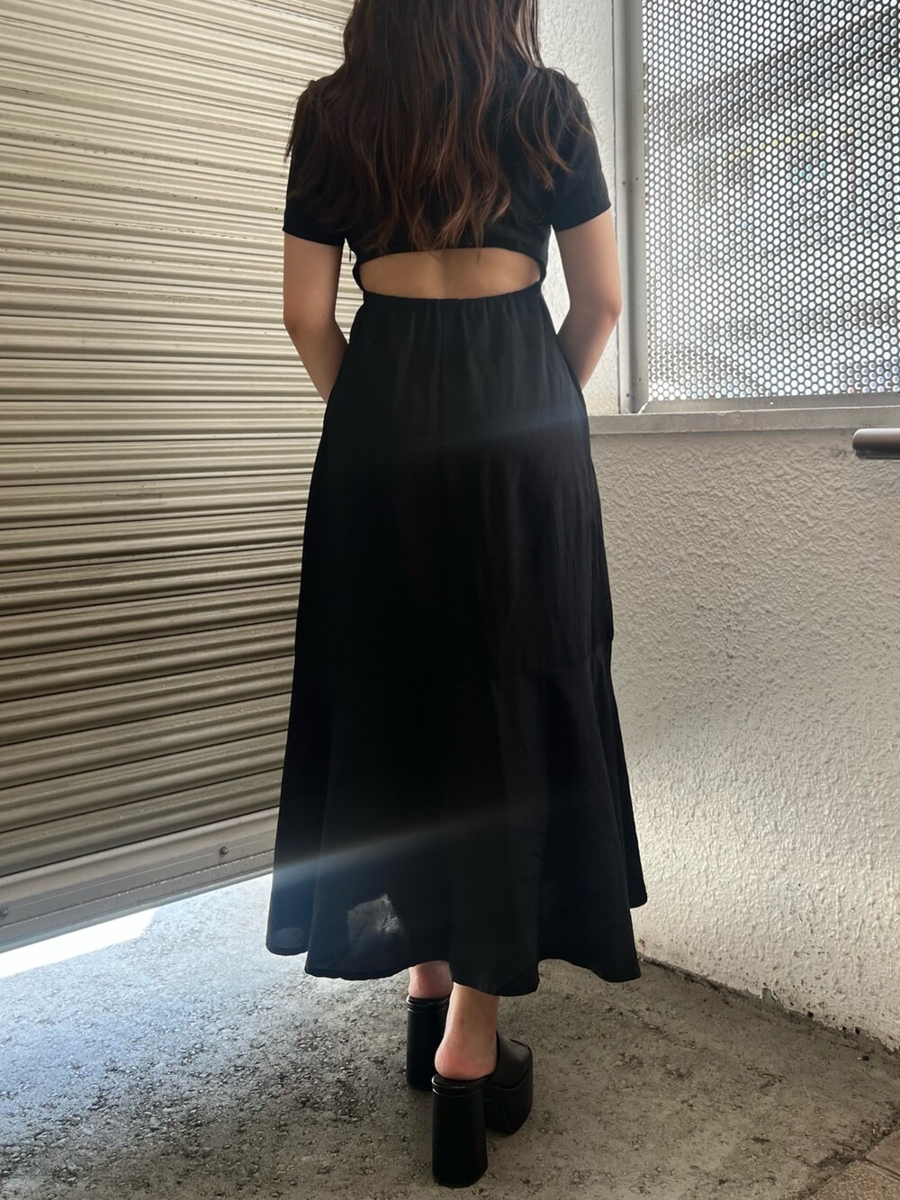 ブラック系のワンピース、ブラック系のショルダーバッグ、ブラック系のサンダルを着用したレディースの夏コーディネートの4枚目の写真