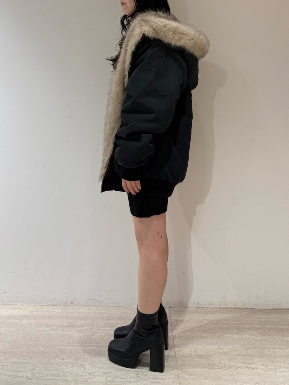 ブラック系のブルゾン、ブラック系のブーツ、ブラック系のワンピースを着用したレディースの冬コーディネートの2枚目の写真