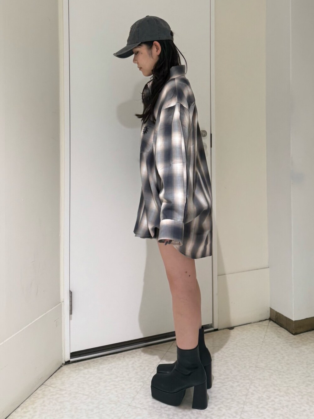 ブラック系のブーツ、グレー系のスカート、ブラック系のシャツ/ブラウスを着用したレディースの夏コーディネートの2枚目の写真