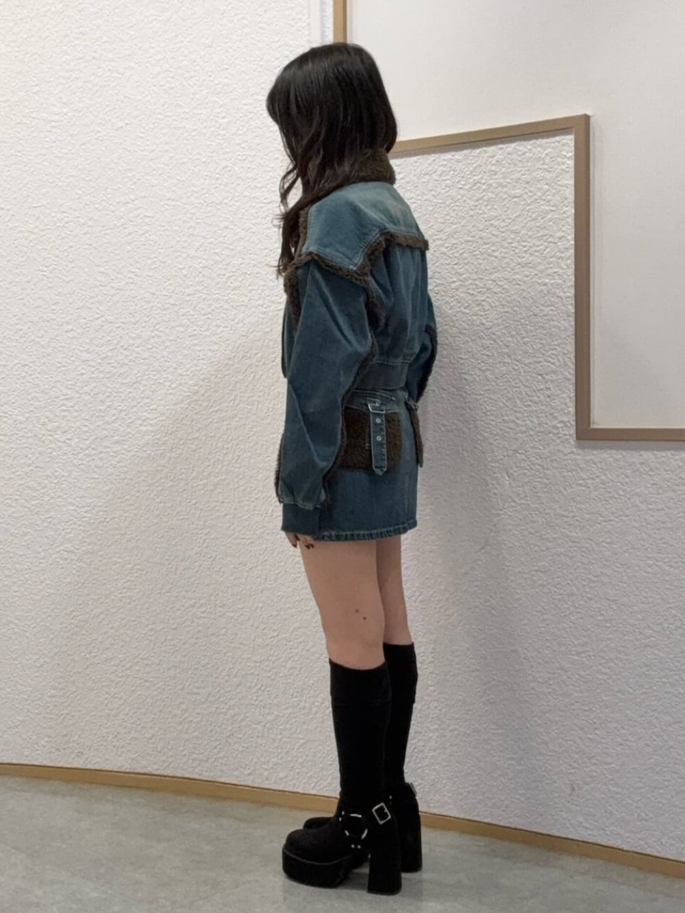 ブラック系のブーツ、ブルー系のブルゾン、ブルー系のデニムスカートを着用したレディースの秋コーディネートの2枚目の写真