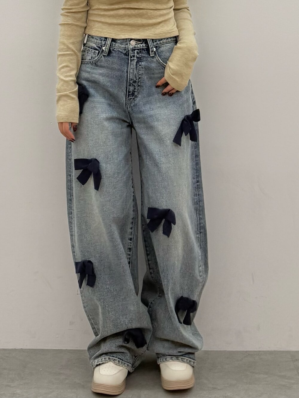 ベージュ系のTシャツ/カットソー、ブルー系のデニムパンツ、ホワイト系のスニーカーを着用したレディースの秋コーディネートの4枚目の写真