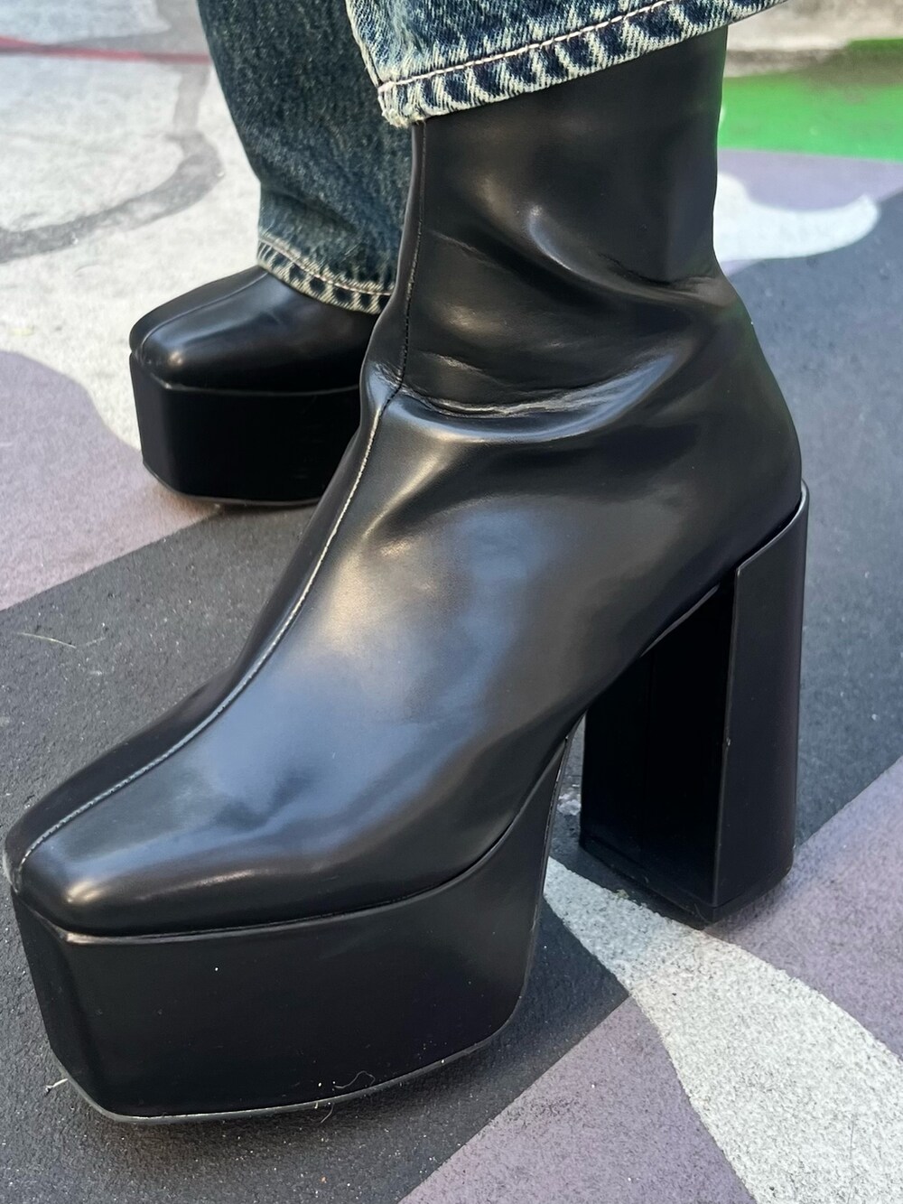 グレー系のチェスターコート、ホワイト系のパーカー、ブラック系のデニムパンツを着用したレディースの冬コーディネートの8枚目の写真