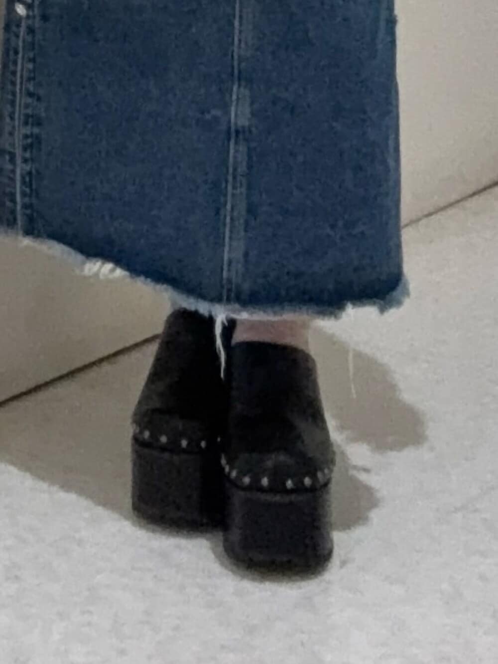 ホワイト系のTシャツ/カットソー、ブラック系のサンダル、ブルー系のデニムスカートを着用したレディースの春コーディネートの5枚目の写真