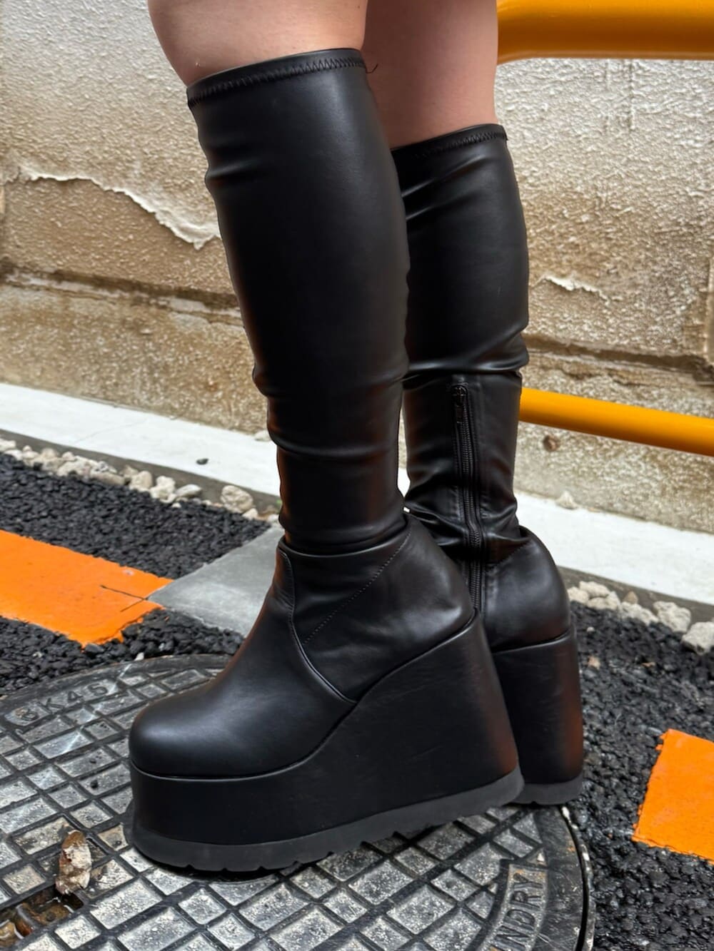 ブラック系のブーツ、ブラック系のワンピース、グレー系のブルゾンを着用したレディースの秋コーディネートの5枚目の写真