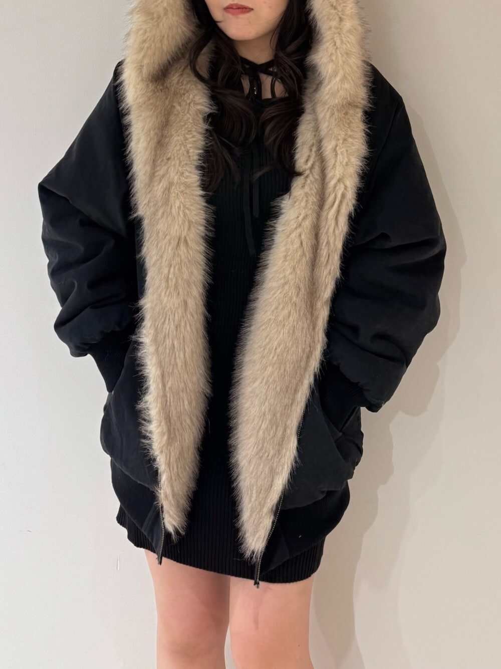 ブラック系のブルゾン、ブラック系のブーツ、ブラック系のワンピースを着用したレディースの冬コーディネートの4枚目の写真