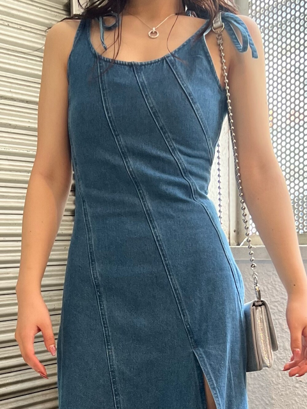 ブルー系のワンピース、ブラック系のサンダル、シルバー系のショルダーバッグを着用したレディースの春コーディネートの4枚目の写真