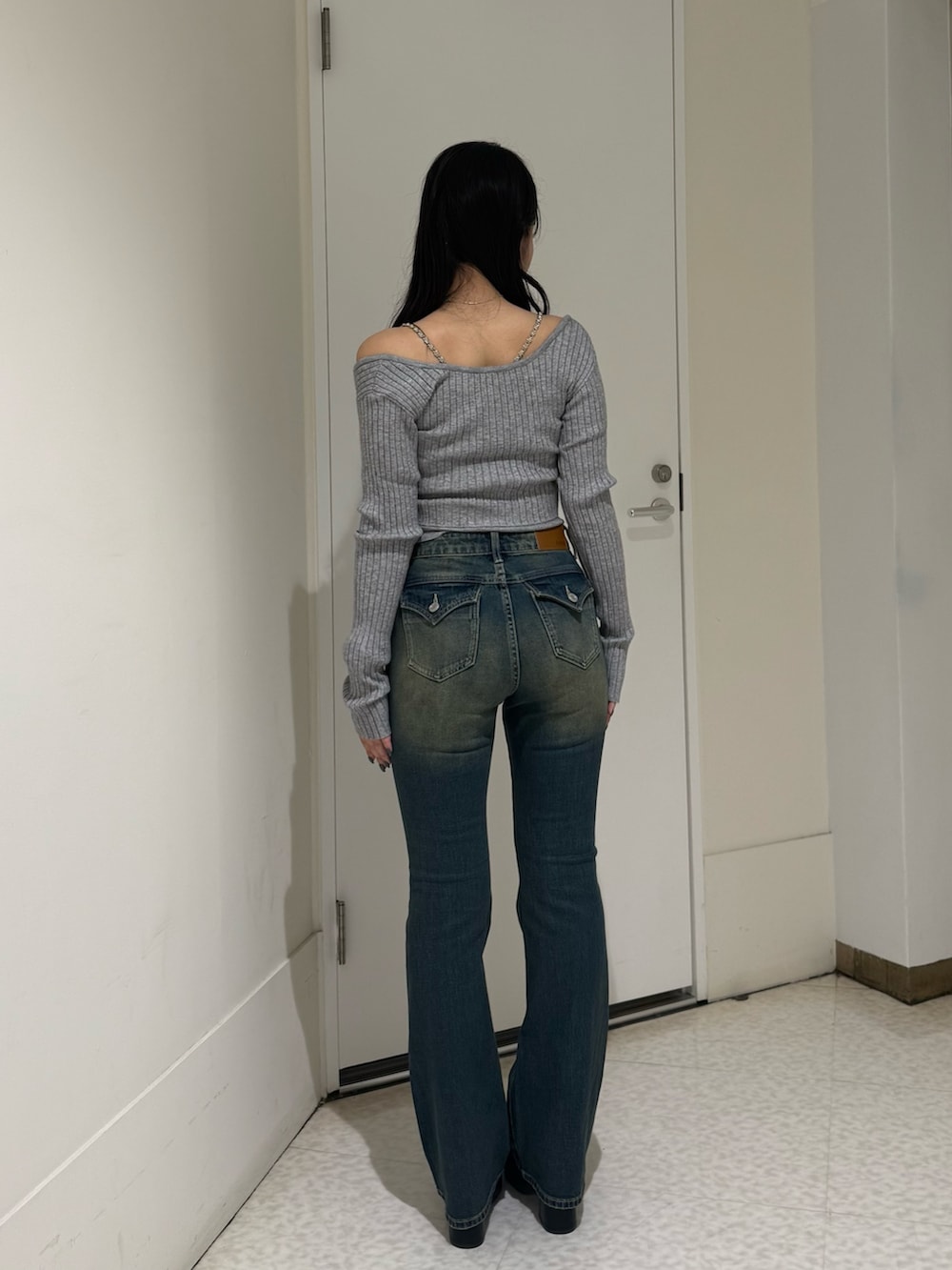 グレー系のニット/セーター、ブルー系のデニムパンツ、ブラック系のブーツを着用したレディースの夏コーディネートの3枚目の写真