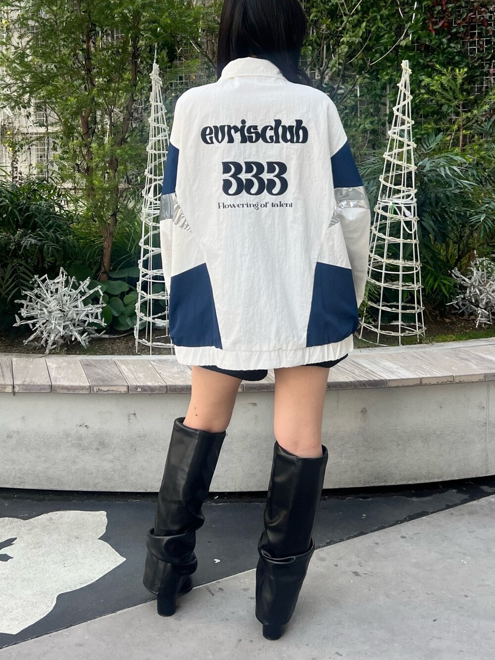 ホワイト系のナイロンジャケット、シルバー系のボディバッグ/ウエストポーチ、ブラック系のブーツを着用したレディースの冬コーディネートの6枚目の写真