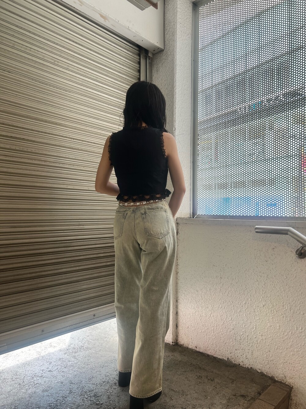 ブルー系のデニムパンツ、ブラック系のサンダルを着用したレディースの夏コーディネートの4枚目の写真