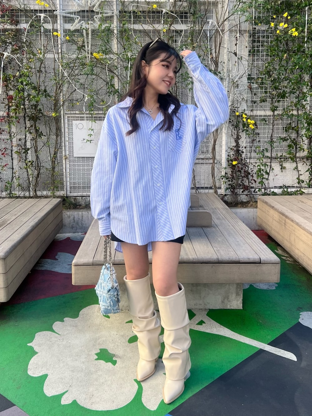 ホワイト系のブーツ、ブラウン系のブルゾン、ブルー系のシャツ/ブラウスを着用したレディースの春コーディネートの4枚目の写真