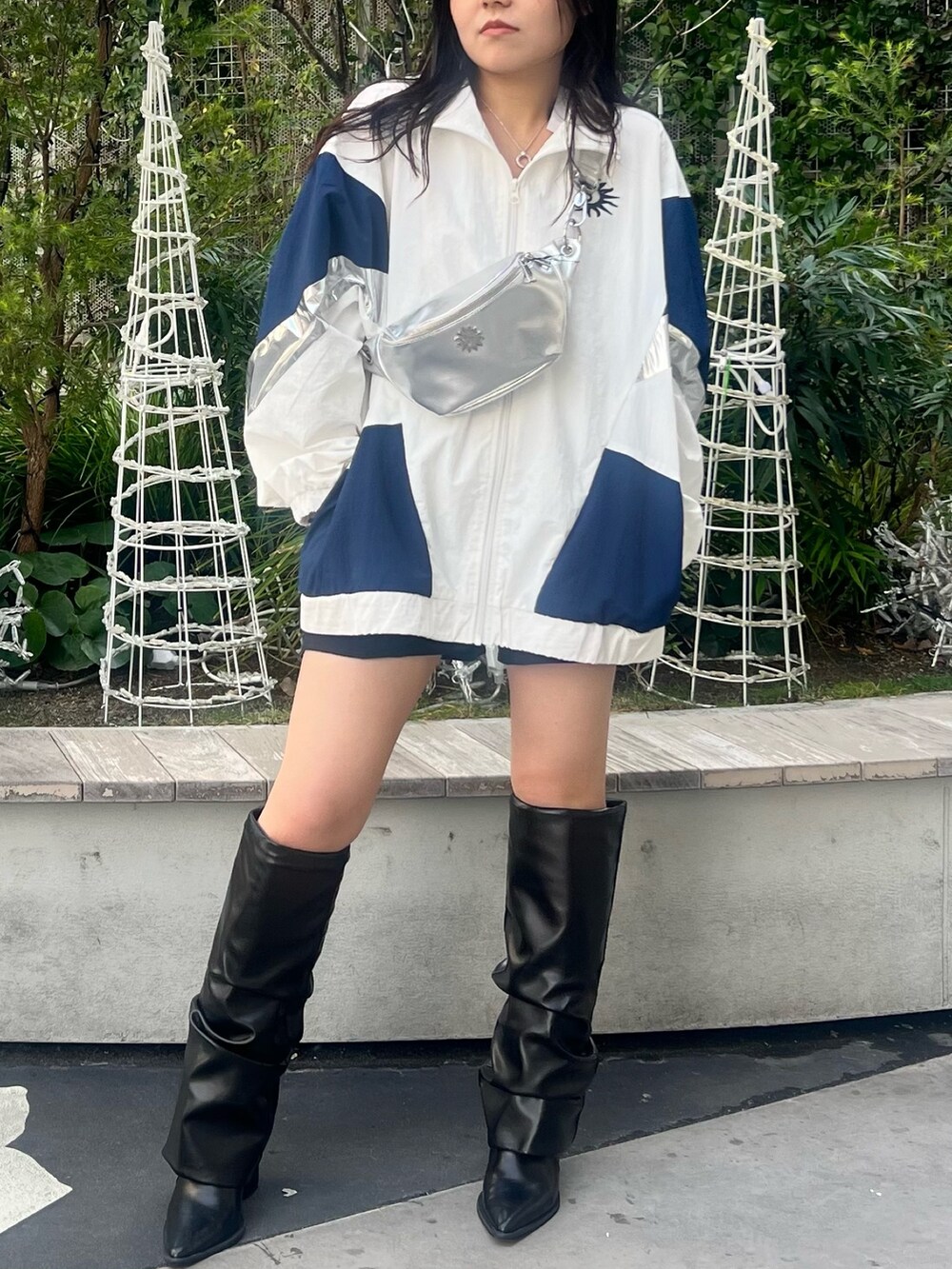 ホワイト系のナイロンジャケット、シルバー系のボディバッグ/ウエストポーチ、ブラック系のブーツを着用したレディースの冬コーディネートの3枚目の写真