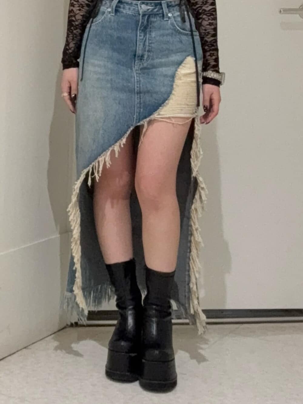 ブラック系のブーツ、ブルー系のデニムスカート、ブラック系のTシャツ/カットソーを着用したレディースの春コーディネートの4枚目の写真